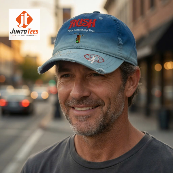 Smiling man wearing a distressed blue ombre Rush concert hat outdoors.