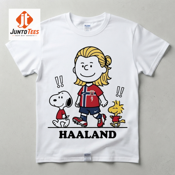 A white unisex t-shirt featuring an illustration of Haaland, Snoopy, and Woodstock in Peanuts comic style.