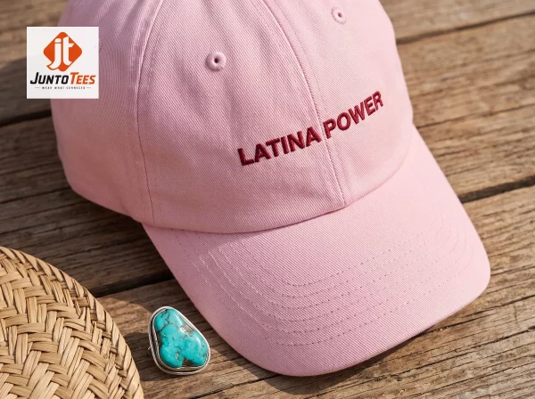 A soft pink cotton baseball cap with Latina Power embroidery in dark red thread.