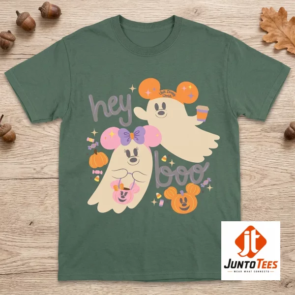 2026 Walt Disney World Parks Hey Boo Mickey and Minnie Ghost Halloween T-Shirt 5 Flatlay of a mauve t-shirt with Mickey and Minnie ghost artwork and candy corn decorations on a wood grain surface. (Detail view #6)