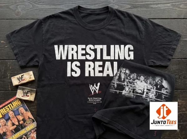 Rey Mysterio Travis Scott WWE Wrestling Is Real T-Shirt 7 A close-up view of a black graphic t-shirt displaying white vintage-inspired Wrestling Is Real text. (Detail view #8)