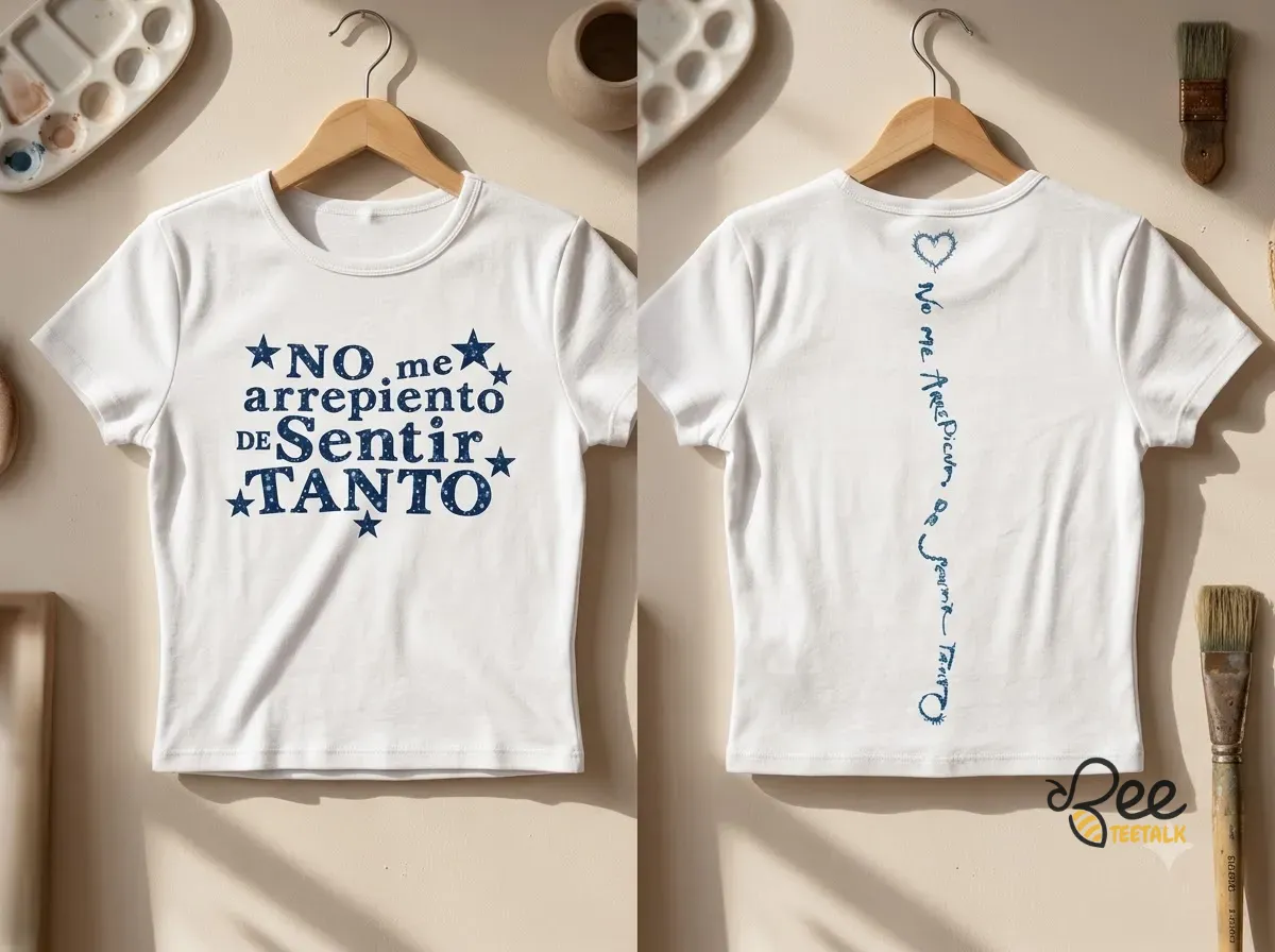Karol G No Me Arrepiento De Sentir Tanto Spanish Quote Crop Women Baby Tee Shirt 2026 3 Front and back view of a white Karol G baby tee with navy blue lyric graphics and star details. (Detail view #2)